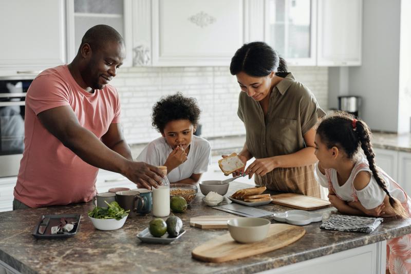 Family preparing meal at kitchen island.